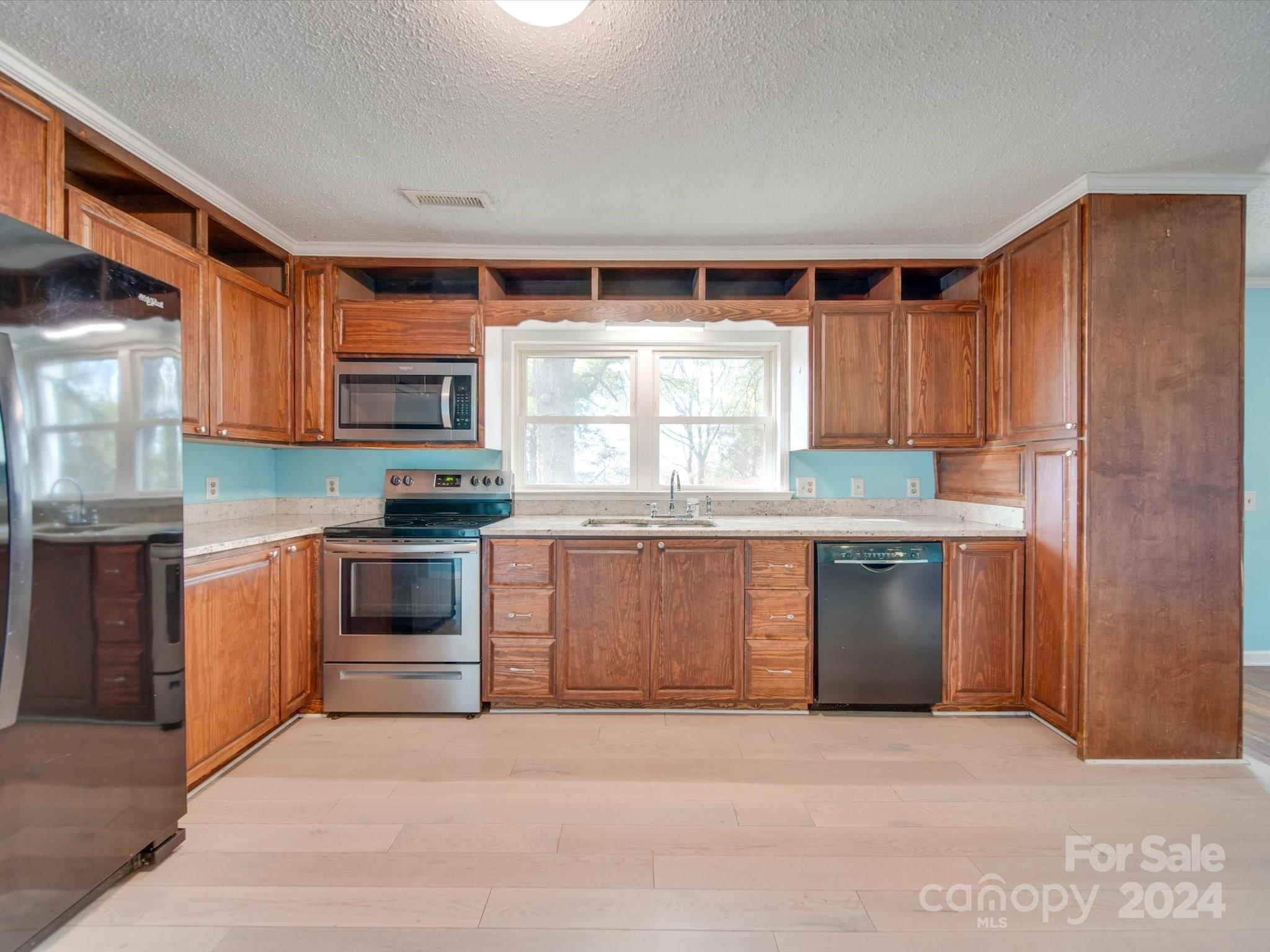 6362 Talley Road Stanfield, NC 28163 - Photo 7 of 39 a kitchen with granite countertop a stove top oven sink and cabinets