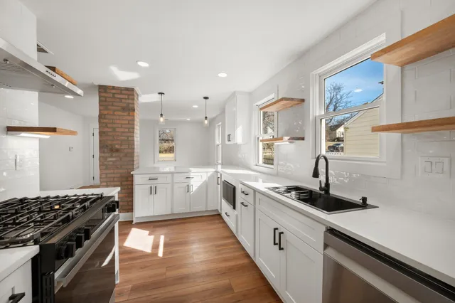 a kitchen with stainless steel appliances a sink stove and cabinets