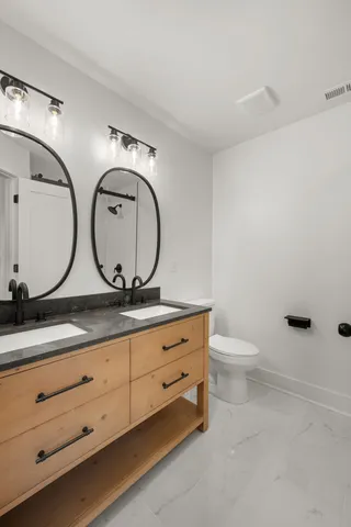 a bathroom with double sink and a mirror