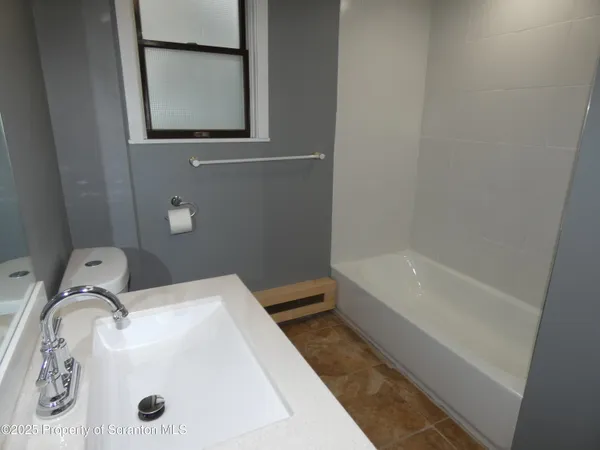an empty room with wooden floor and cabinet