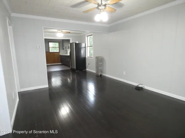 a view of empty room with wooden floor