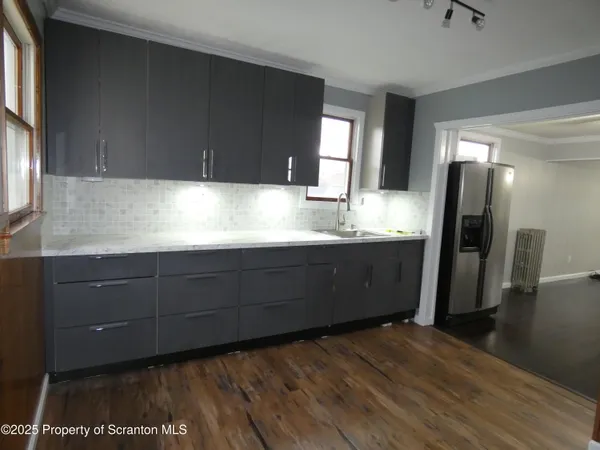 a kitchen with kitchen island a sink appliances and a window