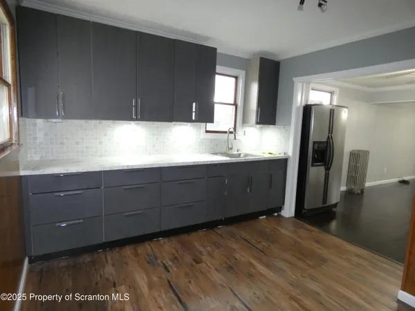 a kitchen with stainless steel appliances granite countertop a refrigerator and a stove top oven