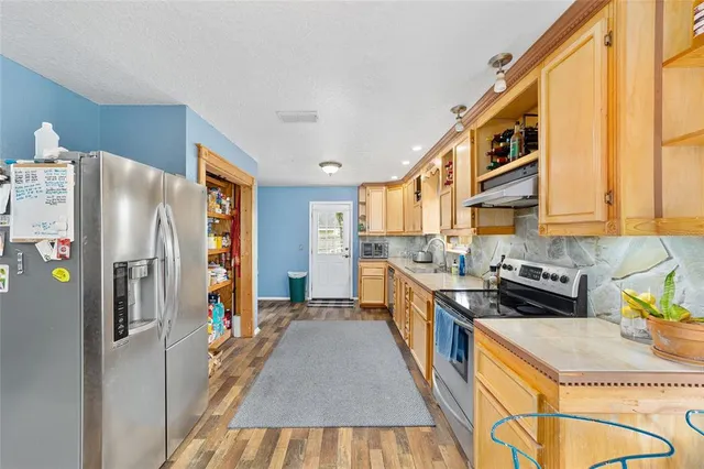 a kitchen with stainless steel appliances granite countertop a stove and a refrigerator