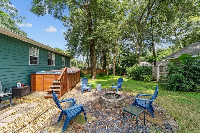 a view of a backyard with table and chairs and a barbeque