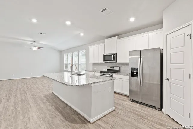 a kitchen with stainless steel appliances a refrigerator sink and microwave