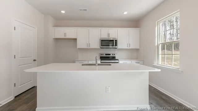 a kitchen with kitchen island a sink a stove and a refrigerator