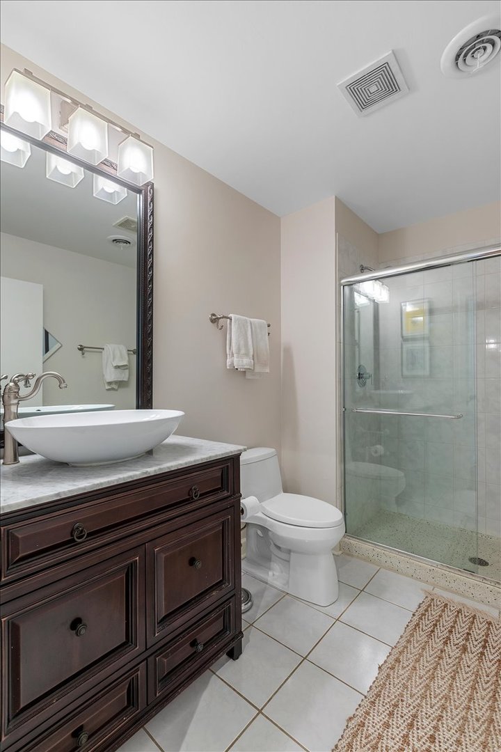 936 West Madison Street, Unit 4C Chicago, IL 60607 - Photo 12 of 16 a bathroom with a toilet a sink and glass door