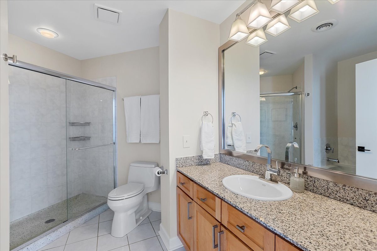 936 West Madison Street, Unit 4C Chicago, IL 60607 - Photo 8 of 16 a bathroom with a granite countertop sink a toilet and a large mirror