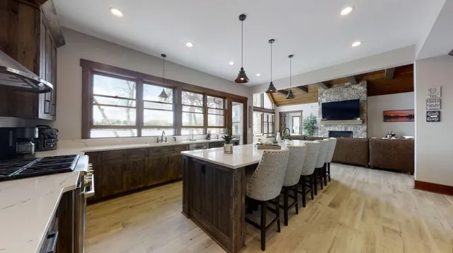 a large white kitchen with a large window and stainless steel appliances