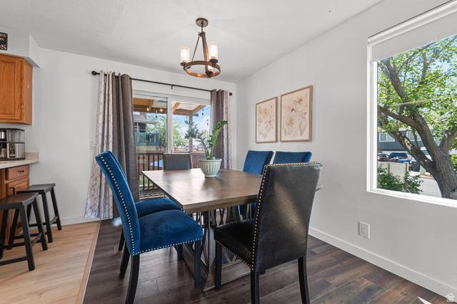 3951 Brixton Road Salt Lake City, UT 84129 - Photo 9 of 22 Dining area featuring wood-finish flooring, a contemporary chandelier, and a sliding glass door providing access to an outdoor area