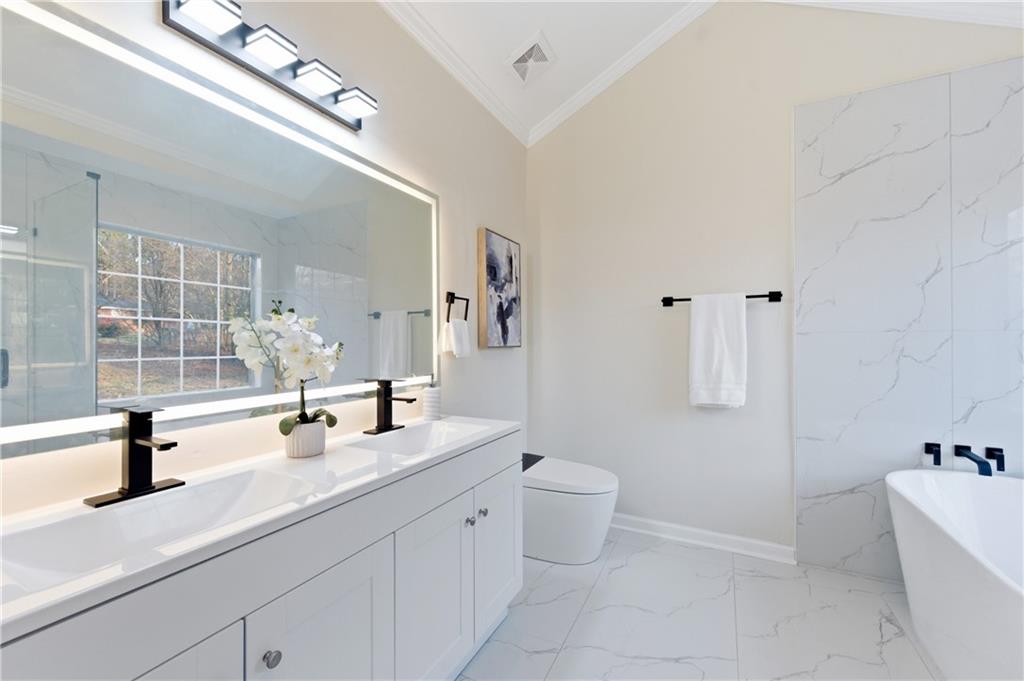 3363 Old Oaks Road Buford, GA 30519 - Photo 14 of 29 a bathroom with a double vanity sink a toilet and a tub