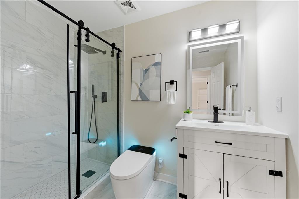 3363 Old Oaks Road Buford, GA 30519 - Photo 19 of 29 a bathroom with a sink toilet vanity and shower