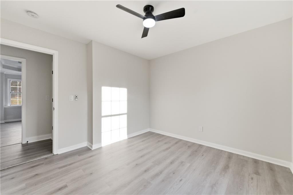 3363 Old Oaks Road Buford, GA 30519 - Photo 20 of 29 an empty room with wooden floor cabinet and windows