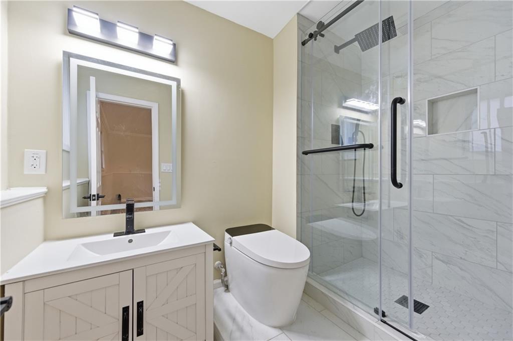3363 Old Oaks Road Buford, GA 30519 - Photo 22 of 29 a bathroom with a sink a toilet and shower