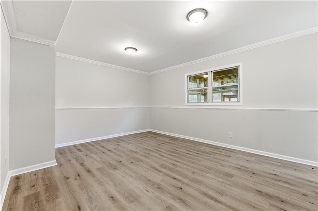 3363 Old Oaks Road Buford, GA 30519 - Photo 23 of 29 an empty room with wooden floor and windows