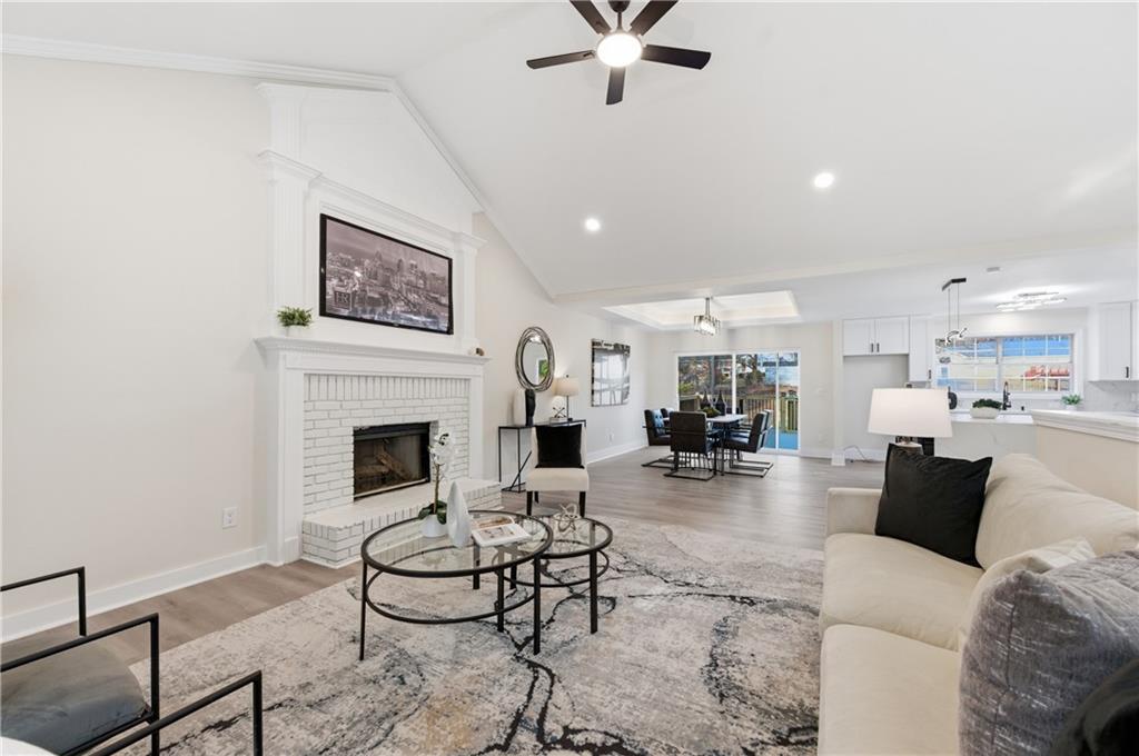 3363 Old Oaks Road Buford, GA 30519 - Photo 6 of 29 a living room with furniture a fireplace and kitchen view