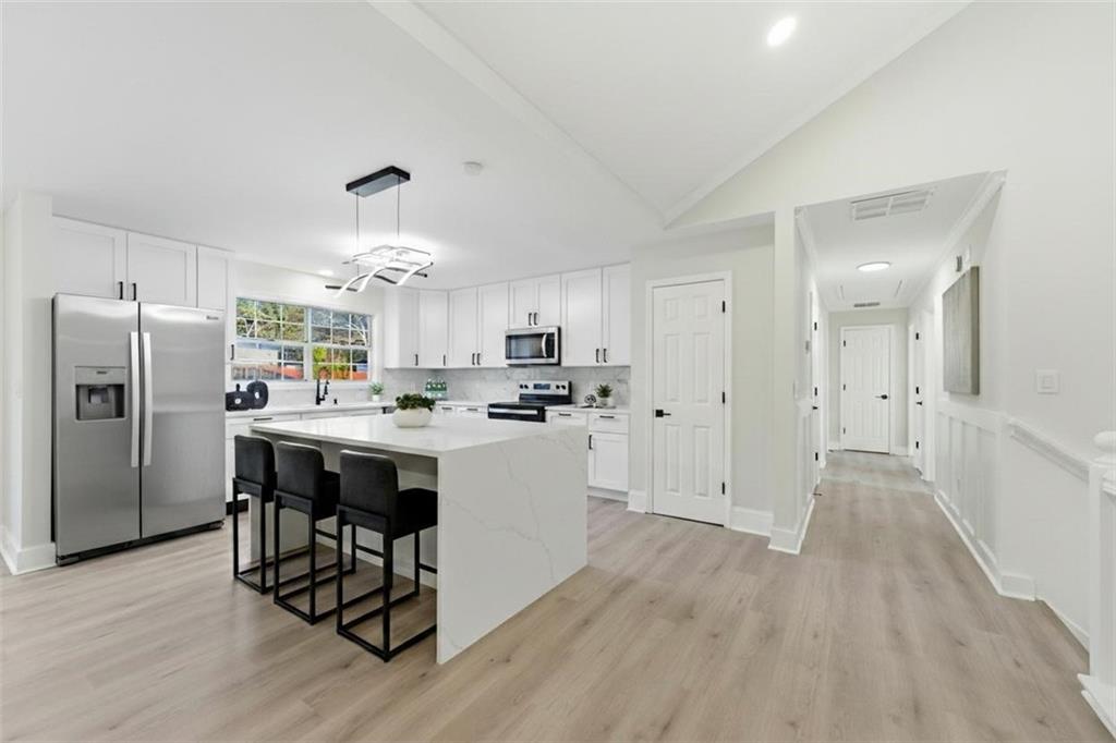 3363 Old Oaks Road Buford, GA 30519 - Photo 8 of 29 a kitchen with refrigerator cabinets and wooden floor