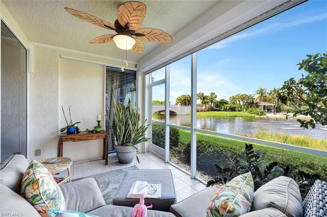 a living room with patio furniture and a floor to ceiling window
