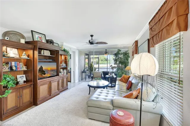 a living room with furniture a flat screen tv and a floor to ceiling window