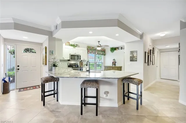 a kitchen with a sink and chairs