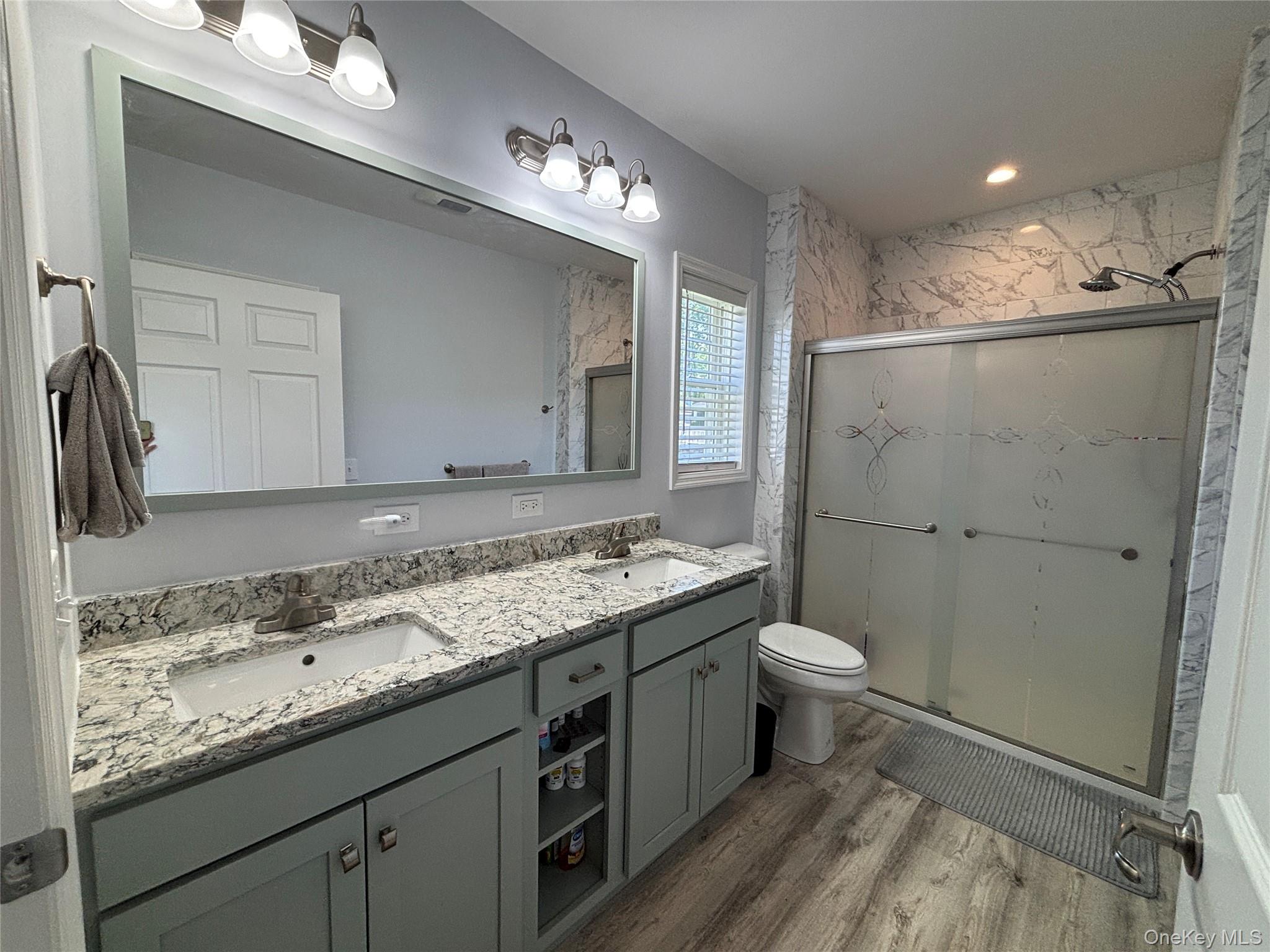 1661 Old Country Road, Unit 563 Riverhead, NY 11901 - Photo 31 of 43 a bathroom with a granite countertop sink toilet and shower