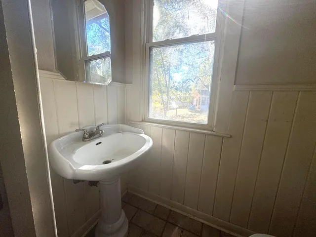 a bathroom with a sink a window and a mirror