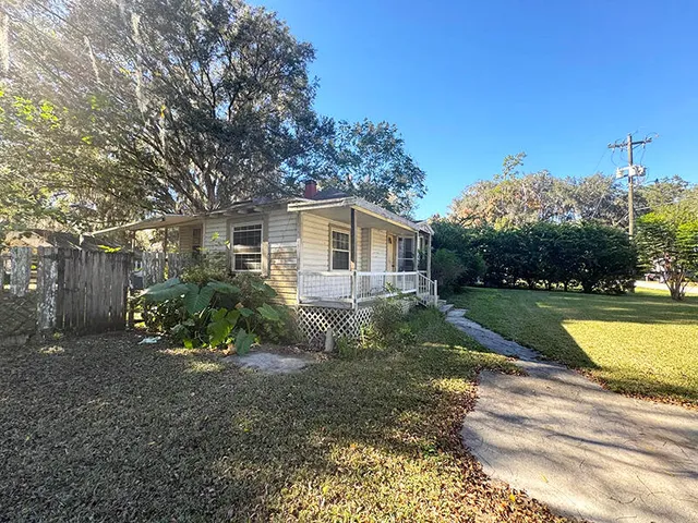 a view of a house with backyard and sitting area