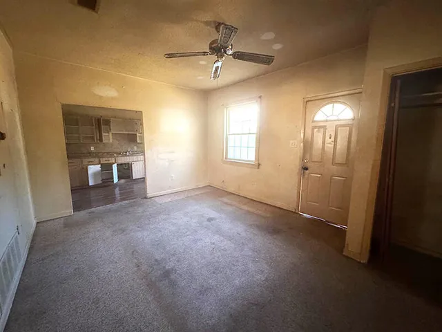 an empty room with fan and windows