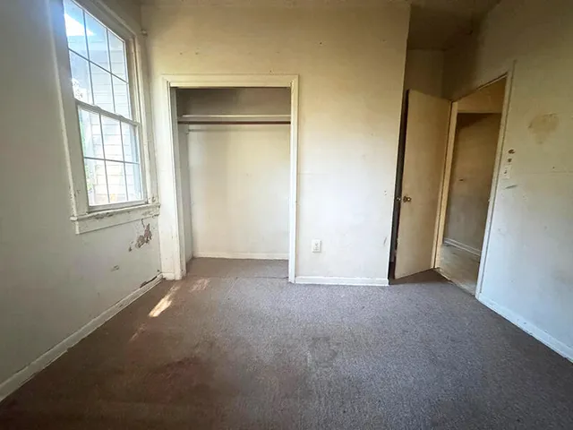 an empty room with windows and closet