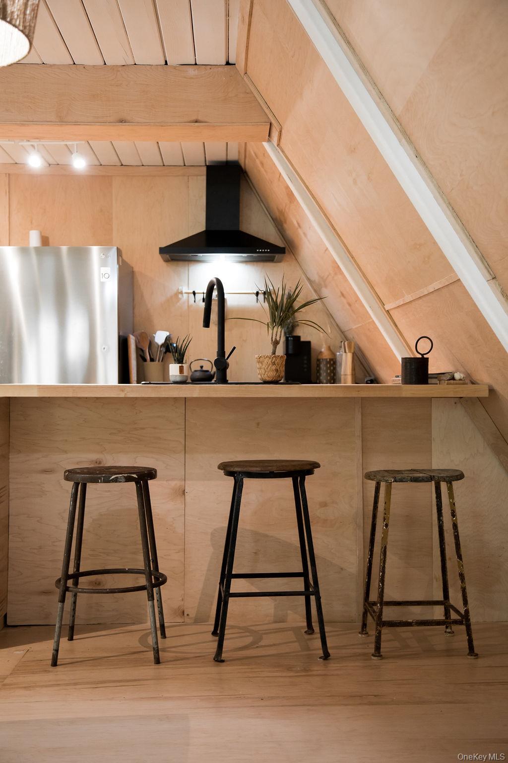 161 Pine Hill Road Shandaken, NY 12410 - Photo 14 of 39 Kitchen featuring wall chimney range hood, freestanding refrigerator, a kitchen breakfast bar, light wood-style floors, and beam ceiling