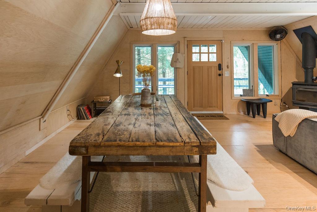 161 Pine Hill Road Shandaken, NY 12410 - Photo 16 of 39 Dining area with a wood stove, wooden ceiling, light wood-type flooring, and wood walls