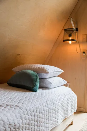 a bedroom with a bed and a lamp on the dresser
