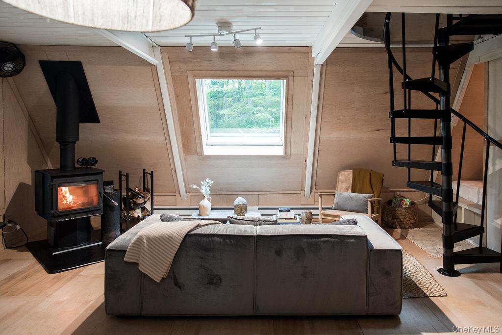 161 Pine Hill Road Shandaken, NY 12410 - Photo 5 of 39 Living room featuring stairs, a wood stove, wood walls, and wood ceiling