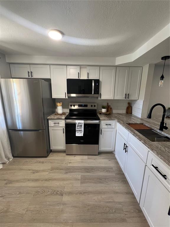 4117 Hampton Drive New Port Richey, FL 34652 - Photo 2 of 23 a kitchen with stainless steel appliances a refrigerator stove and sink