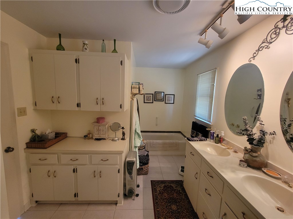 488 Meadow View Road Glade Valley, NC 28627 - Photo 15 of 32 a spacious bathroom with a double vanity sink a mirror and a shower