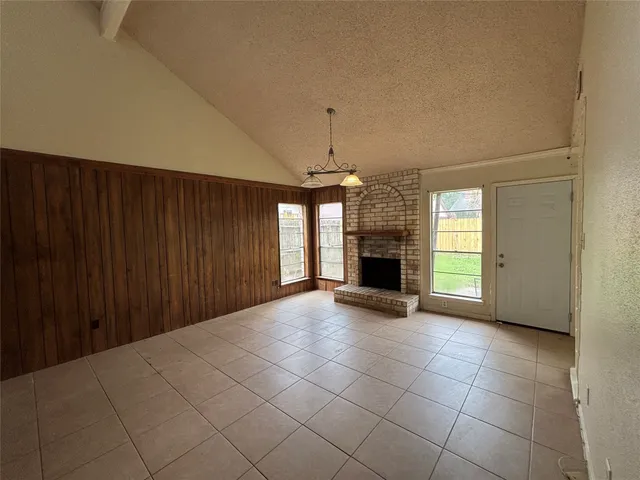 an empty room with fireplace and windows