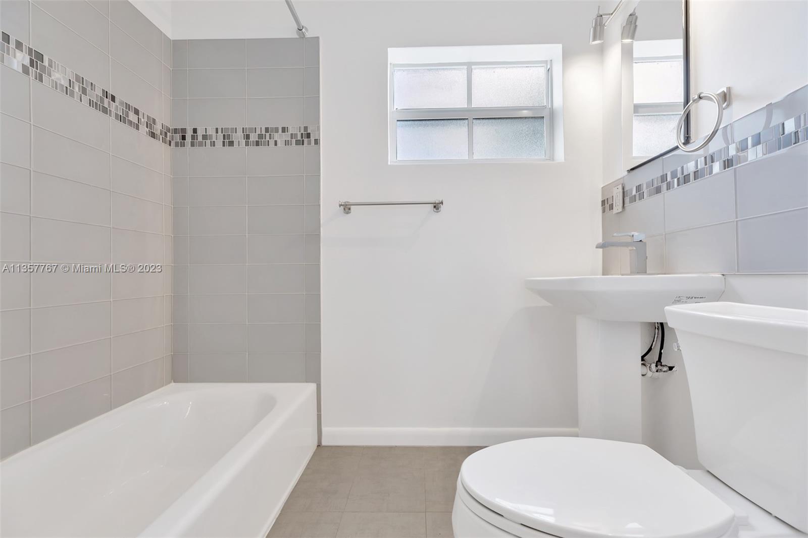 31 South Golfview Road, Unit 2 Lake Worth, FL 33460 - Photo 5 of 18 a bathroom with a white toilet sitting next to a white tub