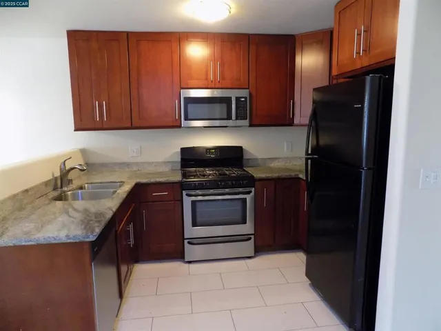 a kitchen with granite countertop stainless steel appliances and wooden cabinets