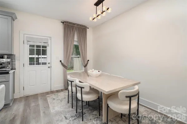 a view of a hallway with white cabinets and wooden floor