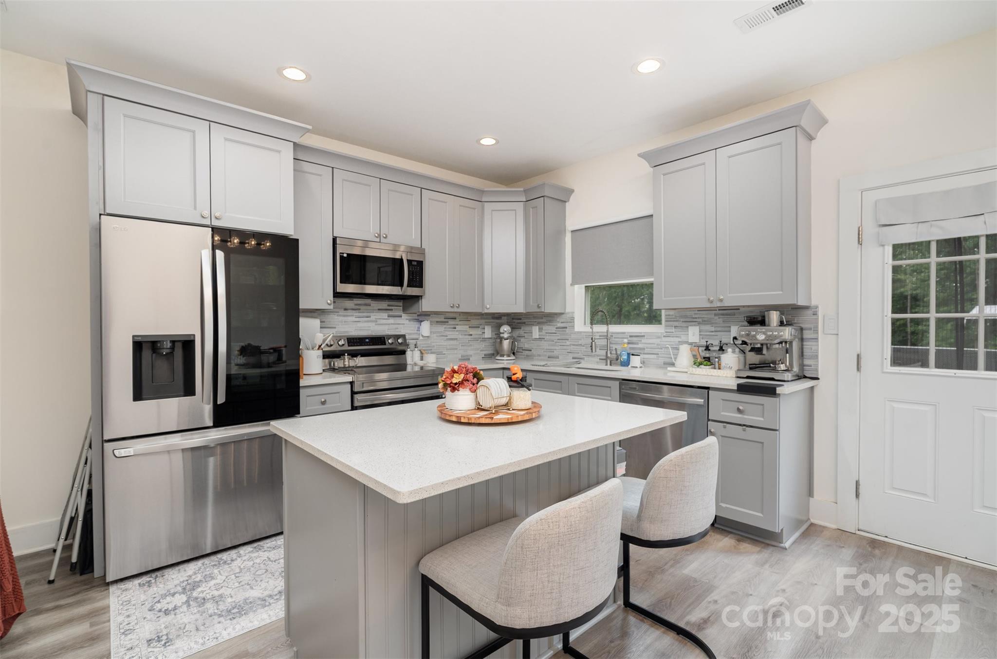 1052 McLain Road Kannapolis, NC 28083 - Photo 14 of 30 a kitchen with stainless steel appliances granite countertop a stove a sink a microwave a refrigerator and white cabinets