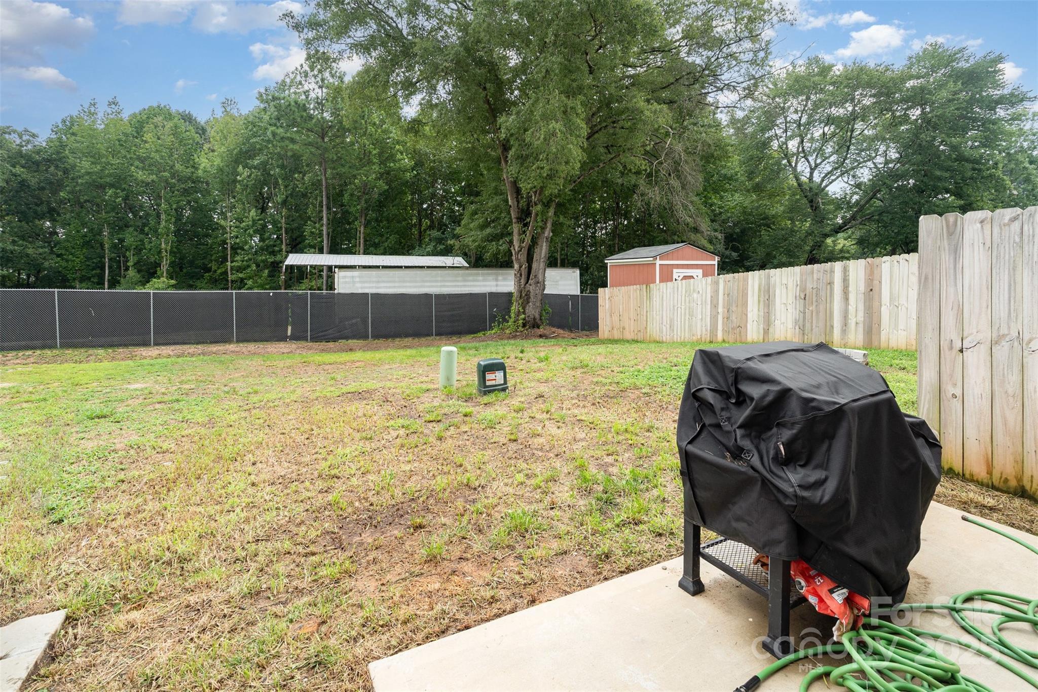1052 McLain Road Kannapolis, NC 28083 - Photo 28 of 30 a view of a back yard with a chair and table in the patio