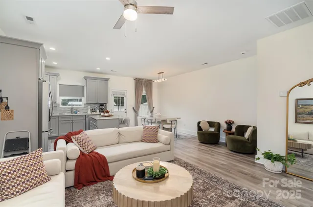 a living room with furniture and a view of kitchen