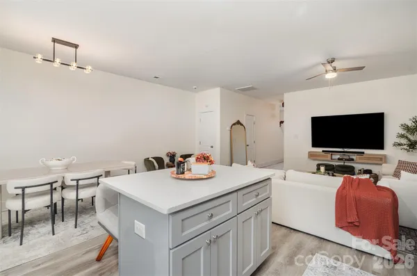 a kitchen with stainless steel appliances granite countertop a stove a sink a microwave a refrigerator and white cabinets