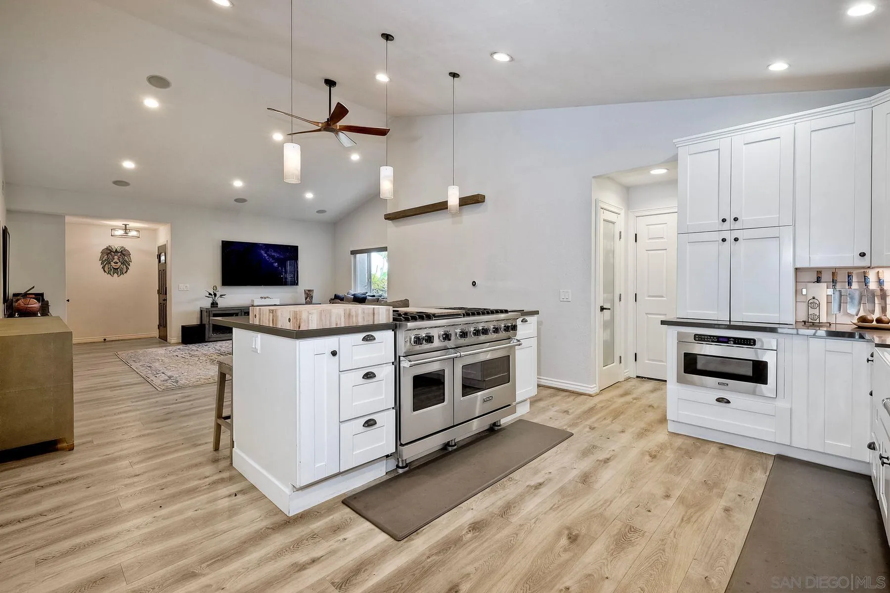 3511 Sitio Baya Carlsbad, CA 92009 - Photo 13 of 42 a kitchen with stainless steel appliances a stove top oven a sink dishwasher and a refrigerator with wooden floor