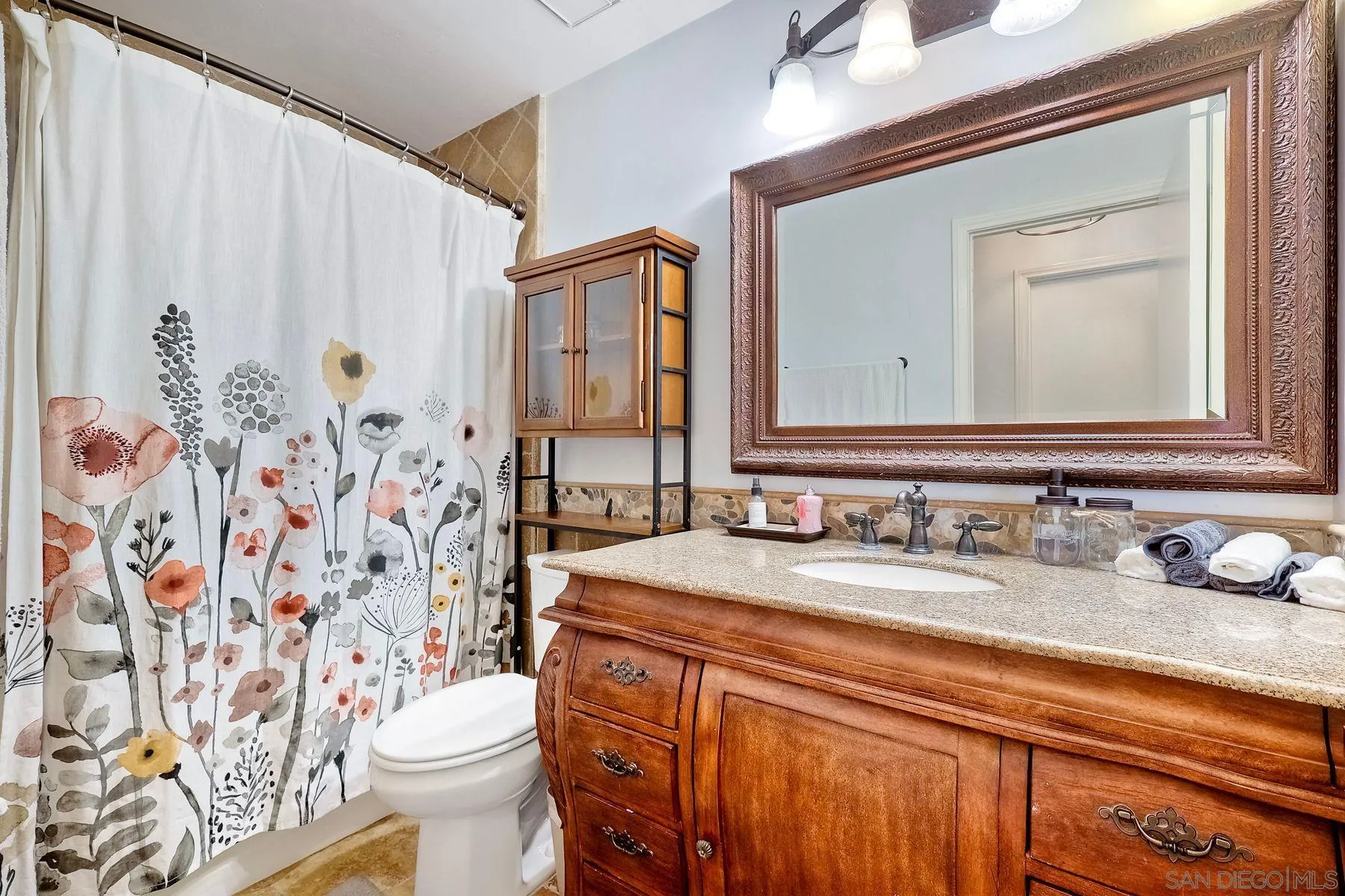 3511 Sitio Baya Carlsbad, CA 92009 - Photo 17 of 42 a bathroom with a granite countertop sink and a mirror
