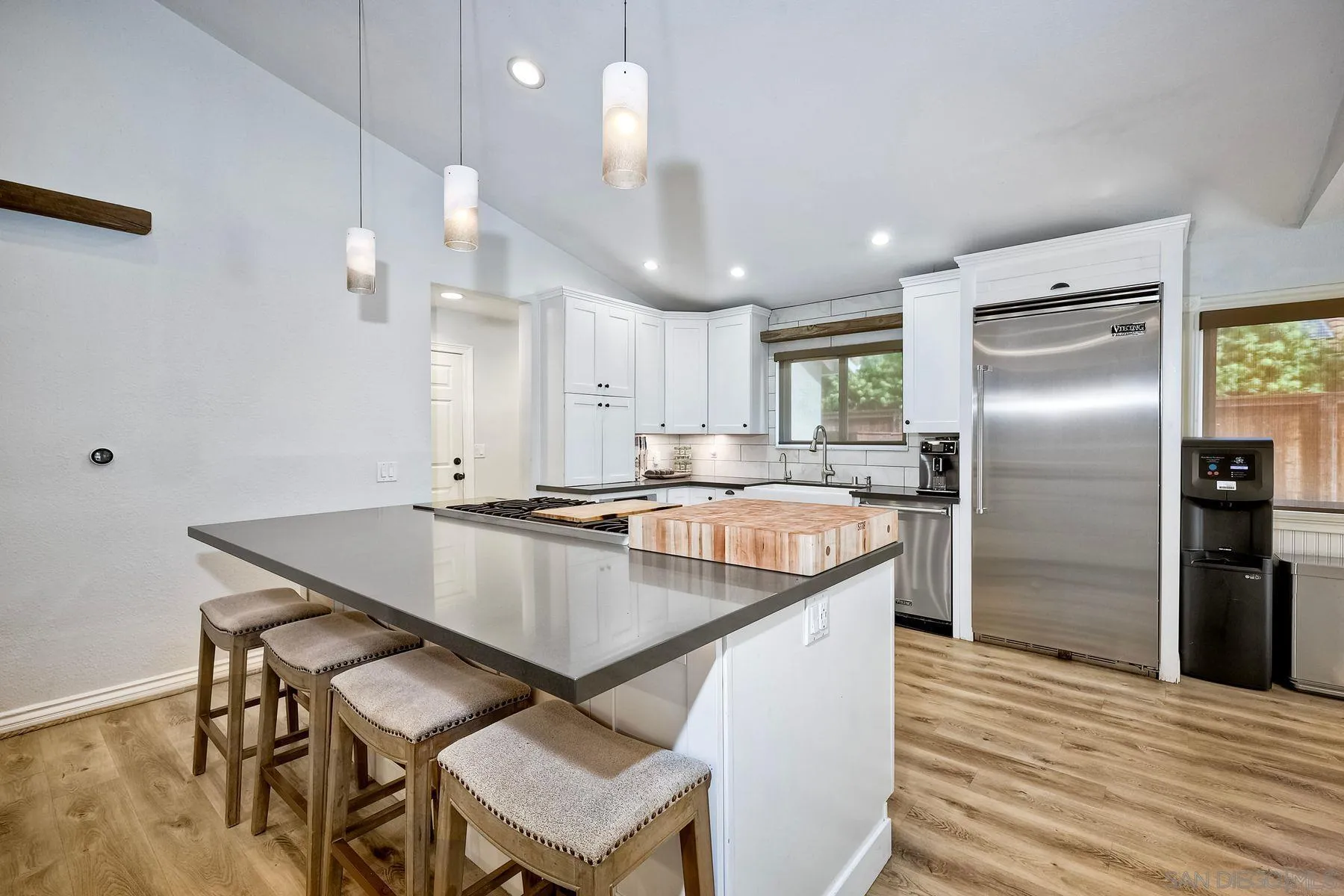 3511 Sitio Baya Carlsbad, CA 92009 - Photo 9 of 42 a kitchen with a table chairs refrigerator and microwave