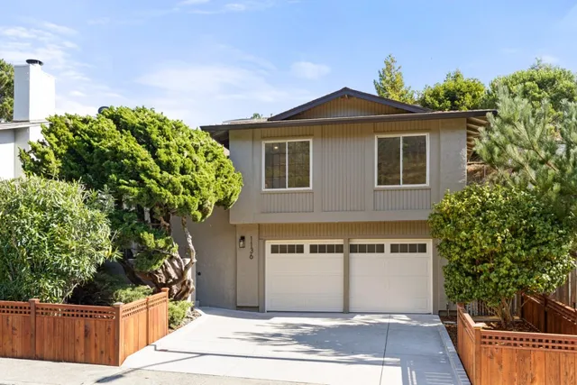 a front view of house with a garden