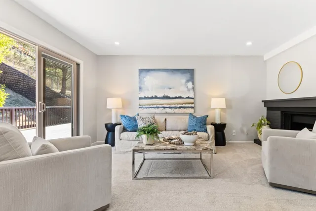 a living room with furniture a fireplace and a large window