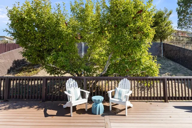 a view of a deck with chairs a barbeque with wooden floor and fence